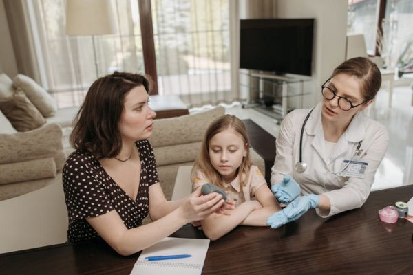 A friendly courier delivering a package of pediatric prescriptions to an Ottawa family doorstep, highlighting stress-free hospital-to-home transition